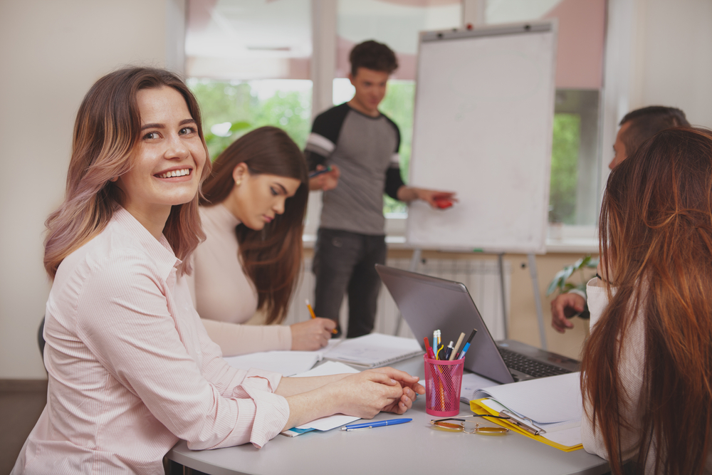 Group of young people studying together at college classroom